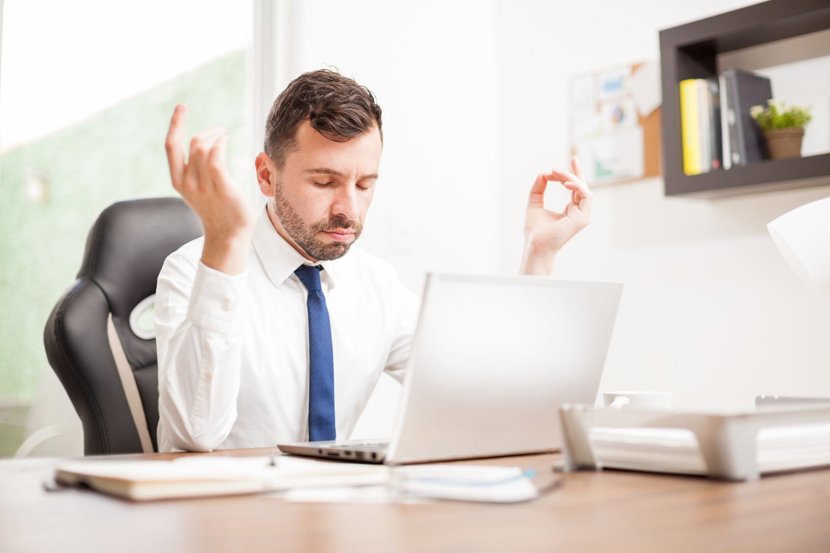 Businessman meditating at his desk