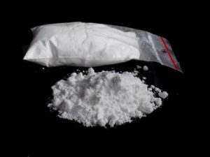 A pile and baggie of cocaine on a table